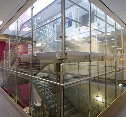 Brushed stainless steel and toughened glass balustrade to an internal school stairwell and glazed atrium